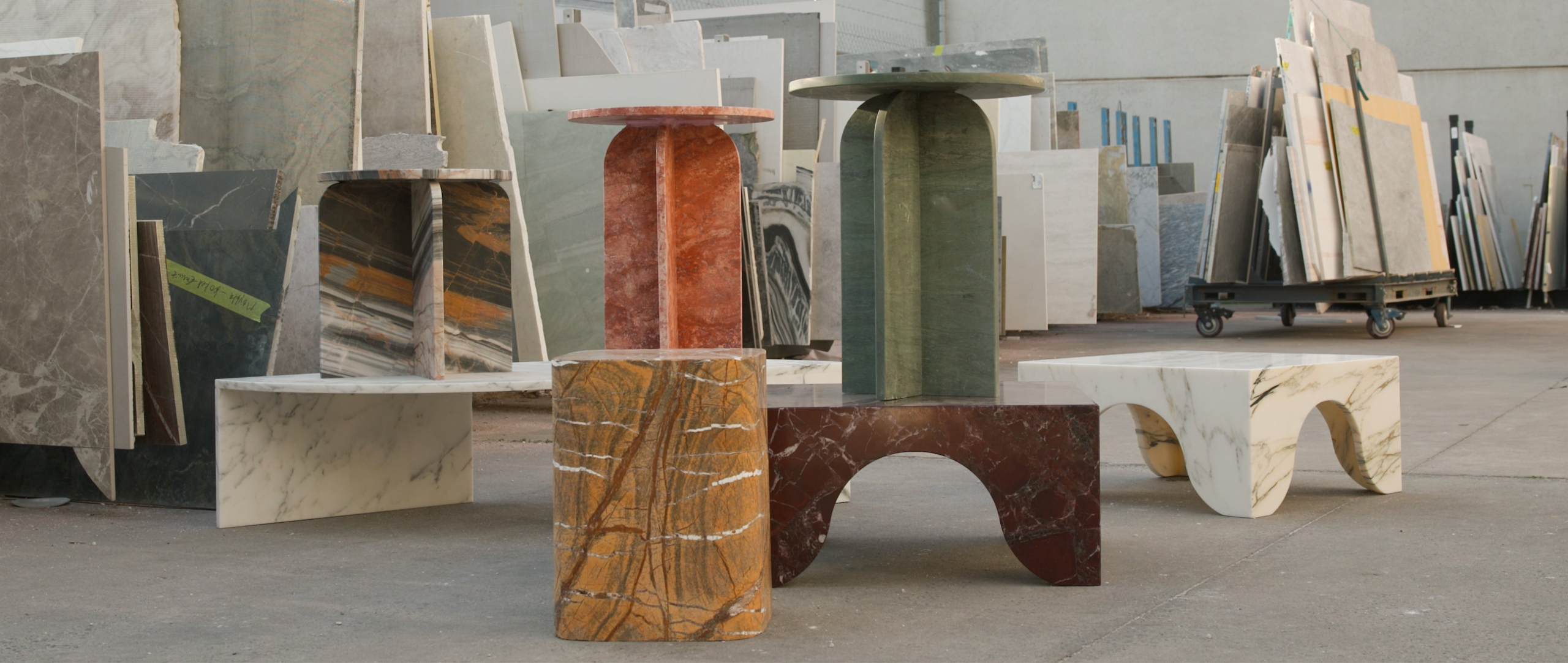 Collection of marble and stone samples displayed in a warehouse setting.