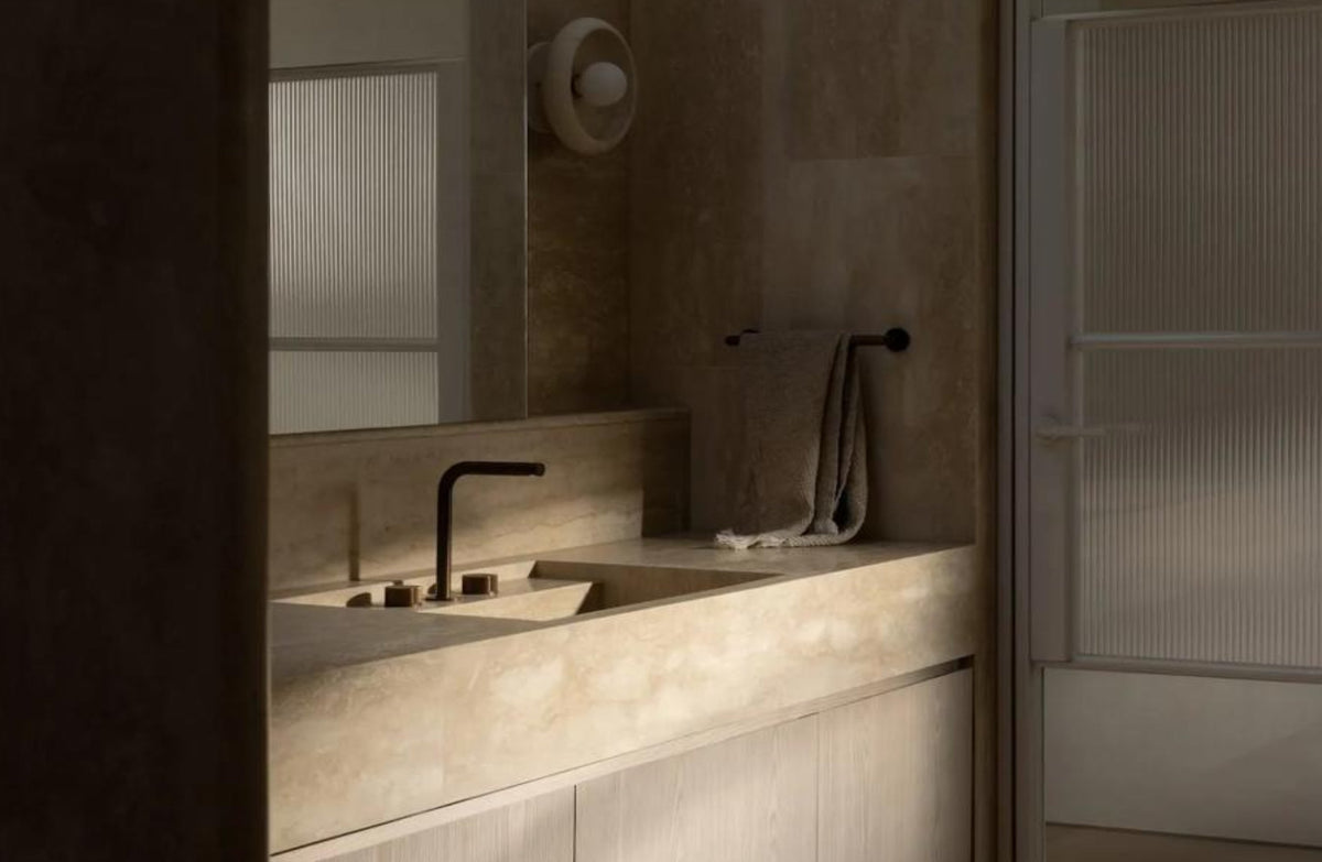 Bathroom vanity with sink, mirror, and towel in a neutral color scheme. 
